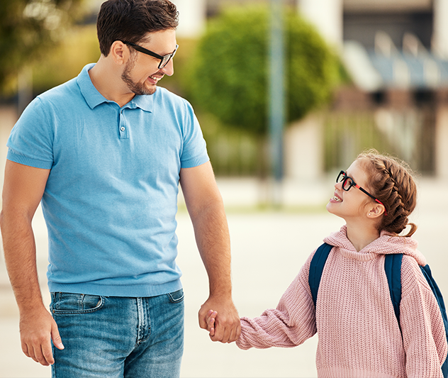Father and daughter wearing glasses and holding hands