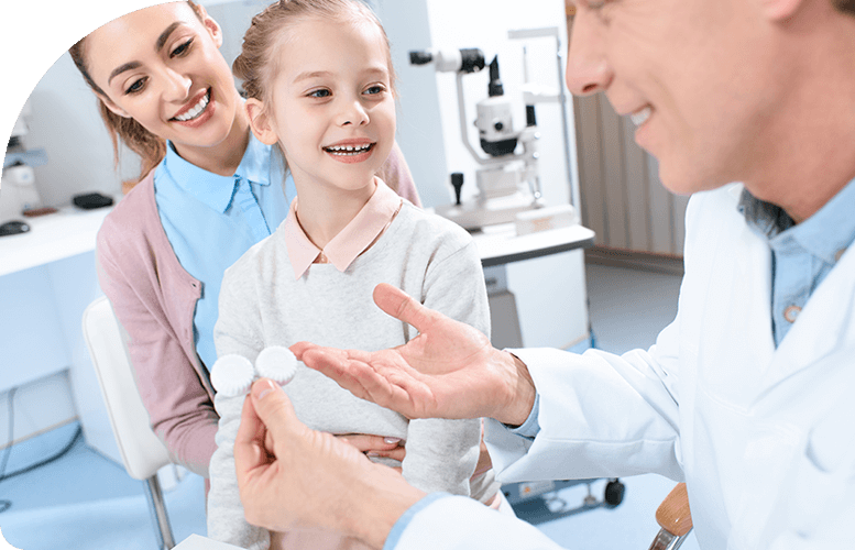 Doctor showing contact lens to mother and daughter
