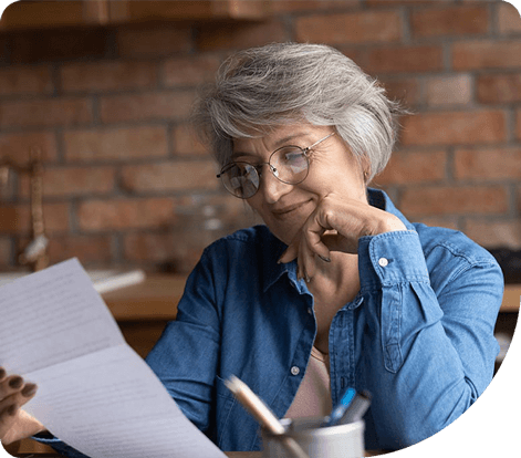 Elderly woman with glasses reading benefits plan