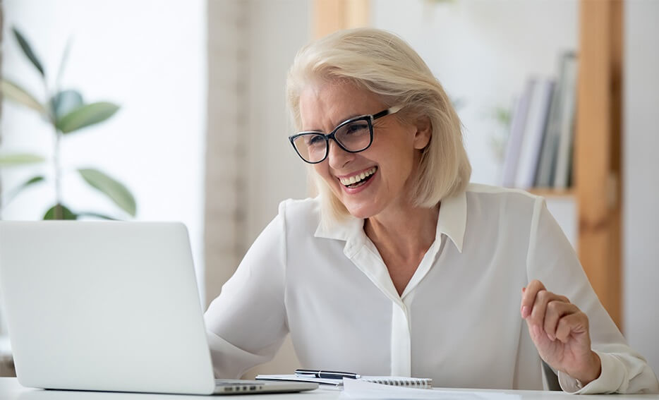 Woman wearing glasses using laptop hero